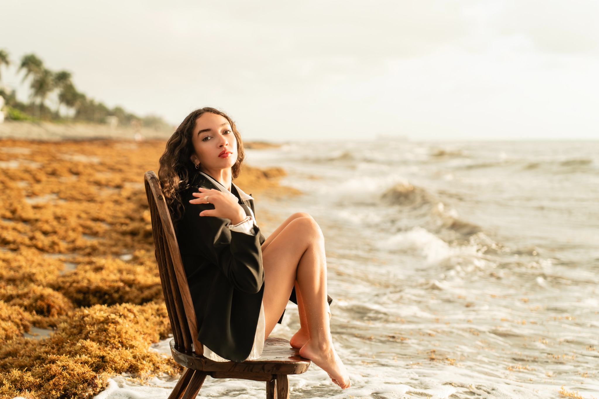 Retrato editorial en la playa con una silla de madera